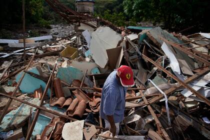 Un hombre busca sobrevivientes entre los escombros de una casa