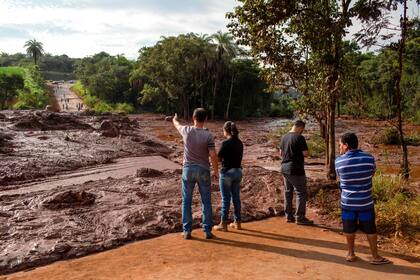 Vecinos de la localidad de Alfredo Torres observan el lodo arrastrado por el colapso del dique minero