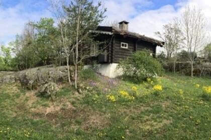La cabaña de troncos está en una isla en una elevación con vistas al fiordo