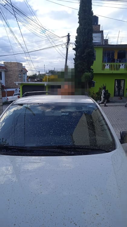 La cabeza sobre el techo del auto en donde yacía inerte Arcos en su interior en el asiento del acompañante