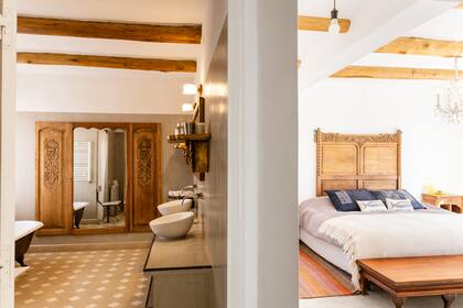 La caja neutra sólo se interrumpe con los muebles antiguos de roble y los textiles de la zona que utiliza como alfombras