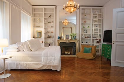 La cama, al mejor estilo hotel cinco estrellas, convive con bibliotecas a medida, pufs de diseño moderno y cómodas antiguas restauradas.