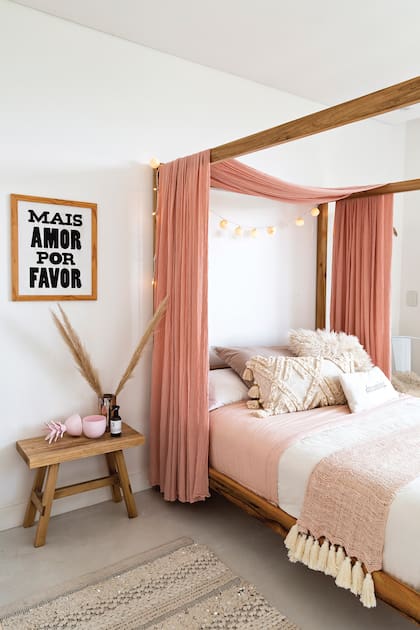 La cama en baldaquino y los telares y tejidos en rosa dan calidez a la habitación de la niña; como mesa de luz, un banco de álamo