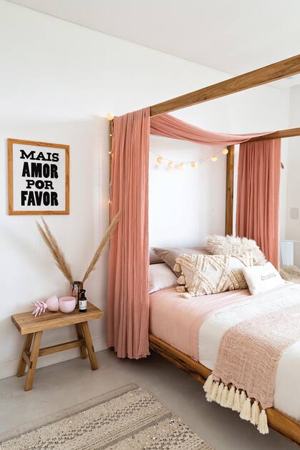 La cama en baldaquino y los telares y tejidos en rosa dan calidez a la habitacin de la nia; como mesa de luz, un banco de lamo