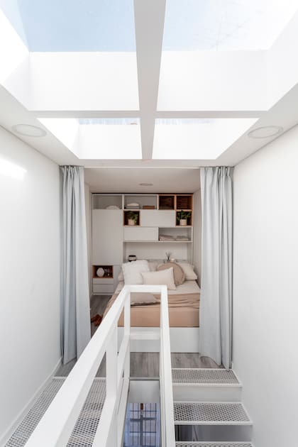 La cama está integrada al mueble (carpintero Mario), que fue concebido como parte de la arquitectura. Ropa de cama (Lote Propio). Vela y difusor con varillas (Bohemia Velas). Piezas de cerámica (Antes Pella).