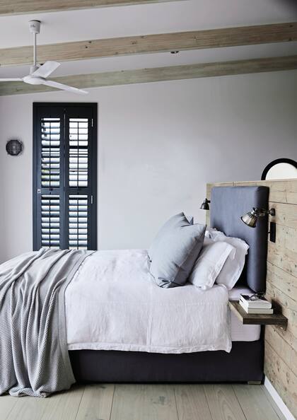 La cama se apoya contra un tabique a media altura que del otro lado funciona como vestidor. Sobre él se amuró un respaldo acolchado