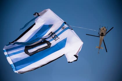 La camiseta gigante que pasea en helicóptero sobre el río, frente al Monumento a la Bandera en Rosario, fue  fabricada en Serodino, tiene 18m x 12m y pesa 60 kg