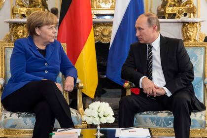 La canciller alemana, Angela Merkel, habla con el presidente ruso, Vladimir Putin, durante una reunión bilateral previa a una cumbre sobre Ucrania en el Palacio del Elíseo en París, Francia, 2 de octubre de 2015. 
