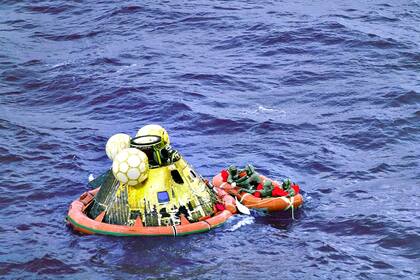 La cápsula que transportaba los tres astronautas del Apolo 11 cayó como estaba previsto, en el mar, a unas 812 millas náuticas al suroeste de Hawai. Varios hombres acudieron al rescate ataviados con trajes de aislamiento biológico para evitar la contaminación que pudieran portar los astronautas