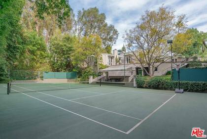 La casa esconde una espectacular cancha de tenis de cemento en su patio trasero (Realtor)