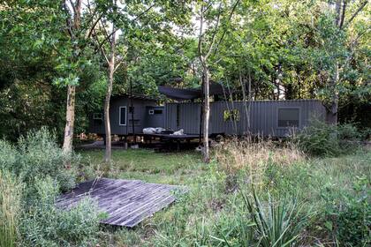 La casa-estudio: La implantación y el proyecto se jugaron sobre dos ejes, uno es la forma de apropiación. Se priorizó la idea de que permanezca presente la topografía con su pendiente hacia el sudeste. Y el otro eje, la configuración material del refugio, un contenedor cuya transformación de uso debía realizarse sin perder la identidad de caja hermética móvil.