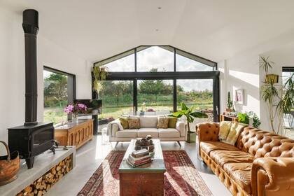La casa negra se destaca por sus amplios ventanales y su interior luminoso