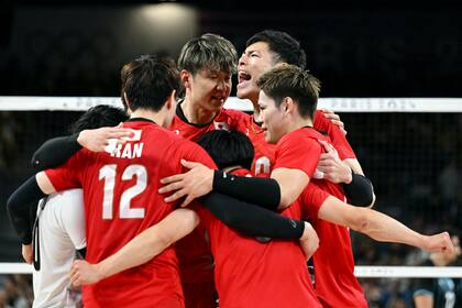 La celebración del equipo japonés después de ganar el segundo set y ponerse 2-0 (Photo by Natalia KOLESNIKOVA / AFP)