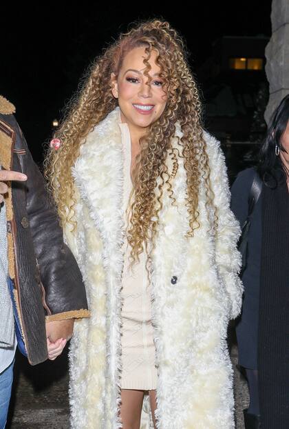 La célebre cantante completó su look con un atuendo en color crema: un vestido corto tejido, un gran saco peludo y botas de caña alta