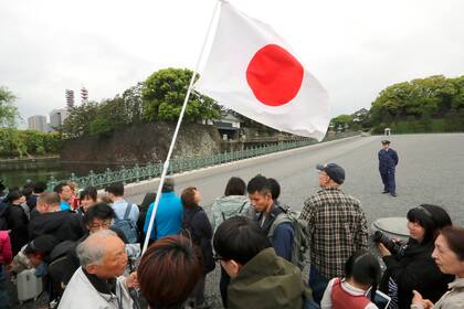 Ante una creciente multitud que se congregó a pesar de una fina llovizna frente al palacio imperial, en Tokio, Akihito realizó el ritual de "informar" sobre su abdicación a sus ancestros.