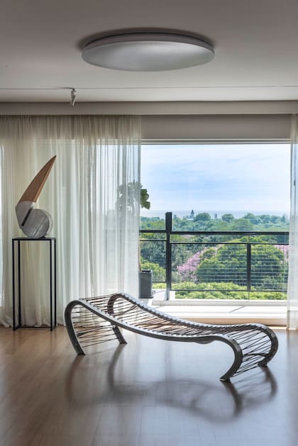 La chaise longue ‘Quenko’, diseñada por Fernando Poggio (Diderot.art) contra el plano de vidrio fijo invita a disfrutar del paisaje. Escultura (Pájaro Gómez) y plafón (Via Luce).