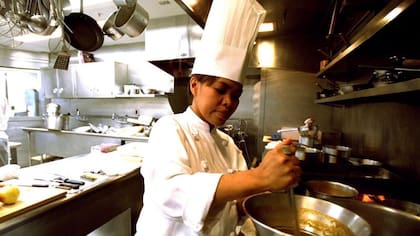 La chef Cristeta Comerford preparando una comida en la Casa Blanca en 2002, antes de hacer historia al alcanzar el cargo máximo en esa cocina
