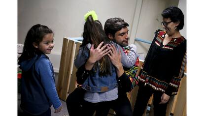 Selenna abraza a un narrador al final de su lectura junto a su amiga transexual Mathilda, en una librería en Santiago, Chile