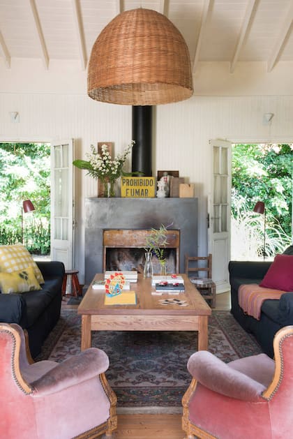 La chimenea de cemento del living se hizo con un conducto importante y a la vista para irradiar más calor al ambiente. A cada lado, lámparas de pie modelo ‘Frida’ (Fiumine).