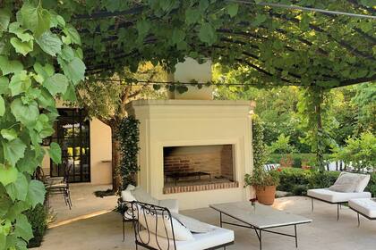 La chimenea permite extender el uso de la galería, cubierta por una parra, cuando el clima es más fresco.