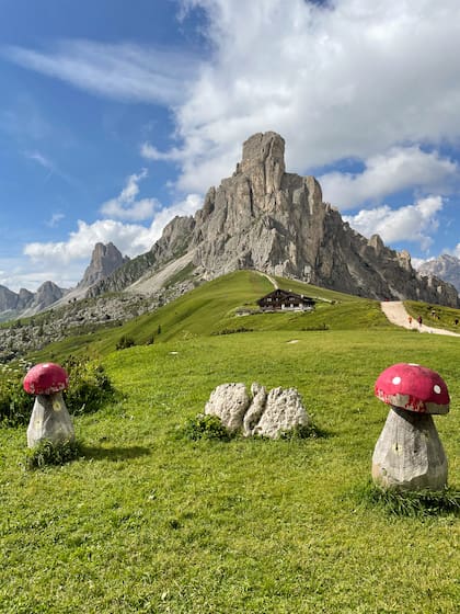 La cima del Passo Giau. Un colchón de pasto verde y una posta de partida (o llegada) de varios senderos que se internan en la montaña.