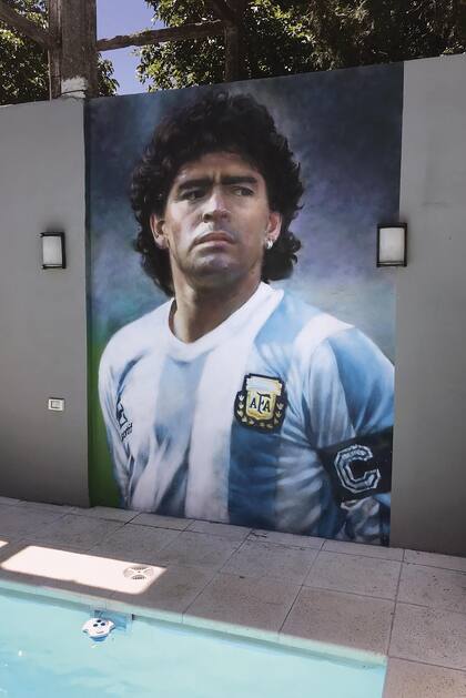 La cinta del capitán, la mirada desafiante de Maradona, en una pared de Buenos Aires. 