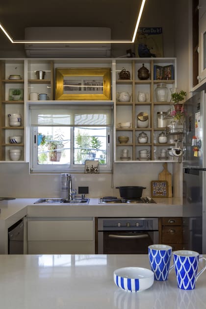 La cocina abierta, reforma esencial para convertir el estudio en vivienda, conserva parte de los muebles originales de madera en convivencia con otros nuevos