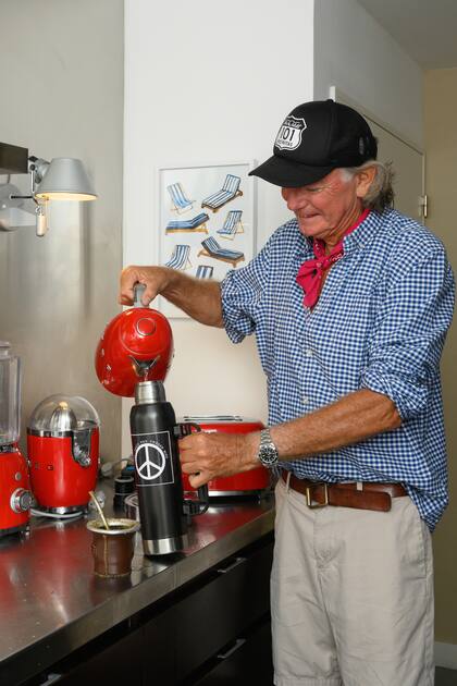 La cocina, con accesorios en color rojo de Smeg. En la pared, un cuadro con reposeras (Matiz).