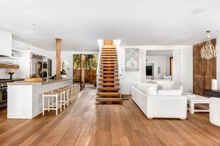 La cocina con una gran barra, salida directa al exterior y conexión con un family room