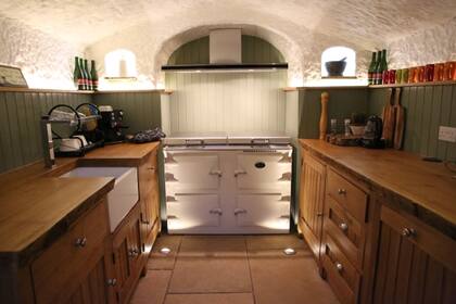 La cocina de Ángelo tiene todas las comodidades y los muebles de madera combinan a la perfección con las paredes de piedra