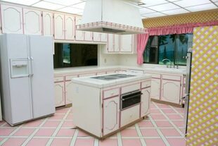 La cocina está decorada en tonos rosas, blancos y amarillos y parece de una casa de muñecas
