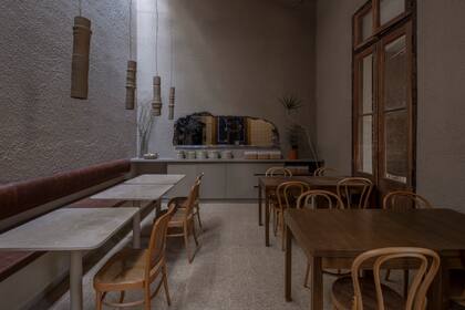 La cocina está expuesta a los comensales a través de un boquete en la pared. Las lámparas de cerámica son creaciones de Flota Objetos (@flota.objetos) y Osis Estudio (@osis.estudio).