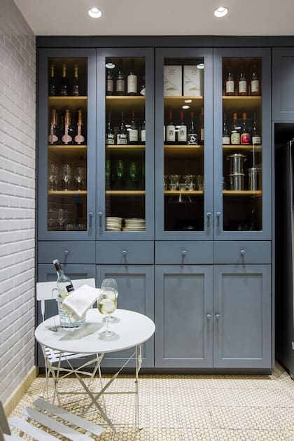 La cocina, impecable, con desayunador y vajillero de piso a techo.