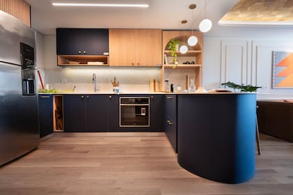 La cocina integrada con el living es imponente, con frente de muebles en Rauvisio Noir (Rehau) que aportan diseño y color.