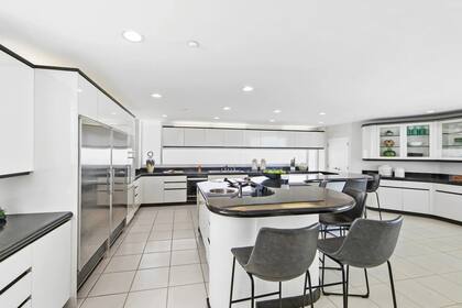 La cocina mesadas de granito negro, electrodomésticos de acero inoxidable, y un amplio ventanal para apreciar el paisaje.