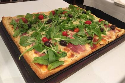 La cocina para delivery y take away de La Casona de Flores incluye pizzas generosas como esta, de hasta 10 porciones