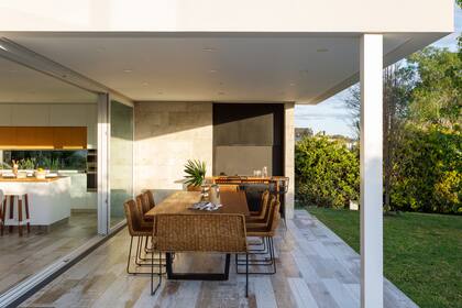 La cocina se integra a la parrilla, con las barras alineadas para que las reuniones fluyan naturalmente entre los espacios. “Almorzamos en la galería, pasamos a los silloncitos después, terminamos en el living, nos movemos por toda la casa”.