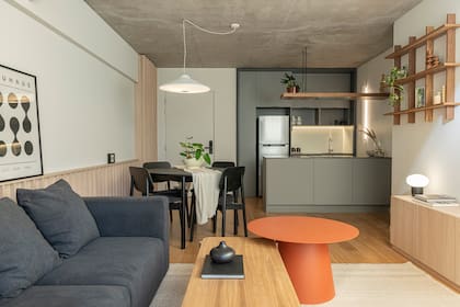 La cocina se integra orgánicamente al living comedor gracias a la elección de colores con el comedor y el sofá gris grafito (Helmut).