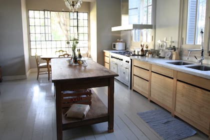 La cocina, también remodelada, cuenta con una mesa rústica de campo en su centro.
