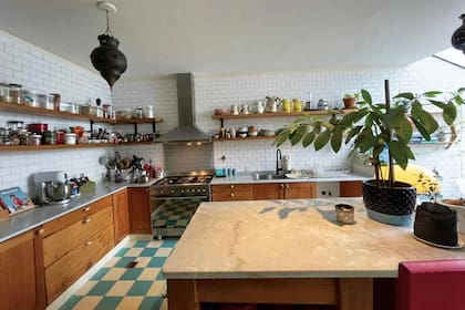La cocina tiene azulejos “Subway”, pisos calcáreos, una isla central con tapa de mármol.