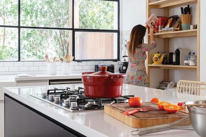 La isla central laqueada (HPS Design, Fabián Portal) tiene anafe y mesada de Silestone en ‘White Storm’.