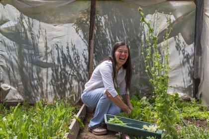 La cocinera, siempre sonriente, recolectando hierbas de su propia huerta.