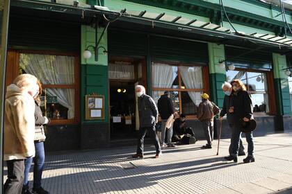 Los clientes esperan afuera del lugar para retirar sus pedidos