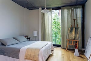 La consigna de la simpleza rige también para la zona de descanso: sábanas de lino gris y acolchado blanco traídos de un viaje, manta de llama (Petite Margot) y cuadros pintados por Martin.