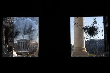 La Corte suprema de EEUU es vista através del vidrio roto de la entrada al Capitolio