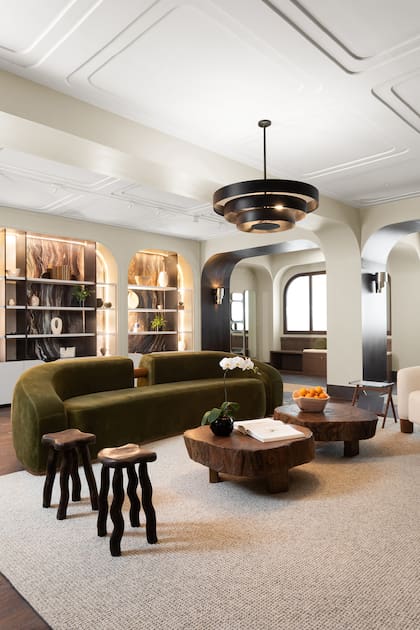 La cuarcita, piedra central del proyecto, se despliega desde la biblioteca en arcos simétricos y recorre el espacio con áreas de asiento y apoyo.