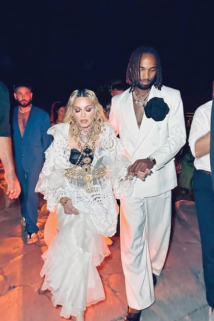 La cumpleañera llegó
de la mano de su novio,
el futbolista jamaiquino
Akeem Morris. Para su gran
día, Madonna eligió un
vaporoso vestido de Dolce
& Gabbana, al que le sumó
maxiaccesorios dorados.
Él llevó saco y pantalón
de la firma italiana GCDS,
que completó con un gran
aplique negro, en forma
de flor, en la solapa.