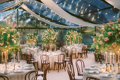 La decoración del salón con velas y rosas blancas y color té.