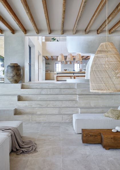 La diferencia de altura entre el estar y la cocina-comedor queda saldada con tres peldaños de piedra Santanyí, un clásico local que reviste todo este piso.