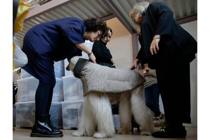 La diseñadora en jefe Silvia Radaelli, izquierda, y la diseñadora de moda Giovanna Temellini prueban un abrigo en Ulisse,